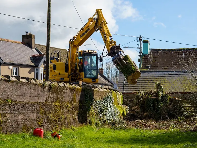 Using heavy machinery to life heavy timber over wall